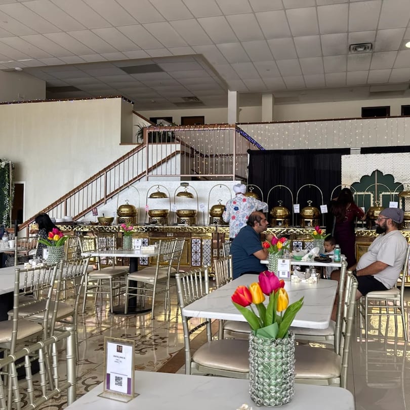 Diners enjoying Indian cuisine at Grand Dhaba, with a buffet line and elegant decor.